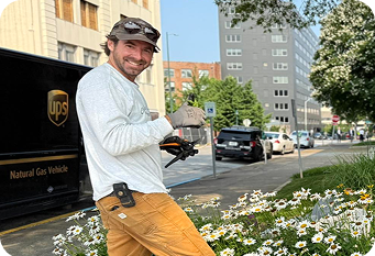 A man planting flowers in front of Chattanooga's City Hall Building.