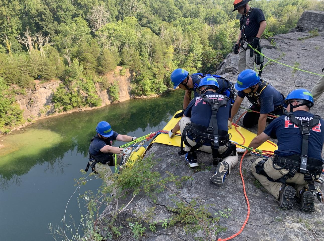 Un grupo de personas en un acantilado, utilizando una cuerda de operaciones especiales para su misión.