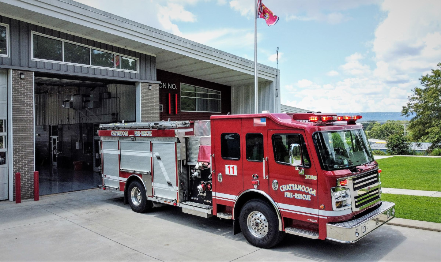 Red fire truck parked in front of building at fire station 11.