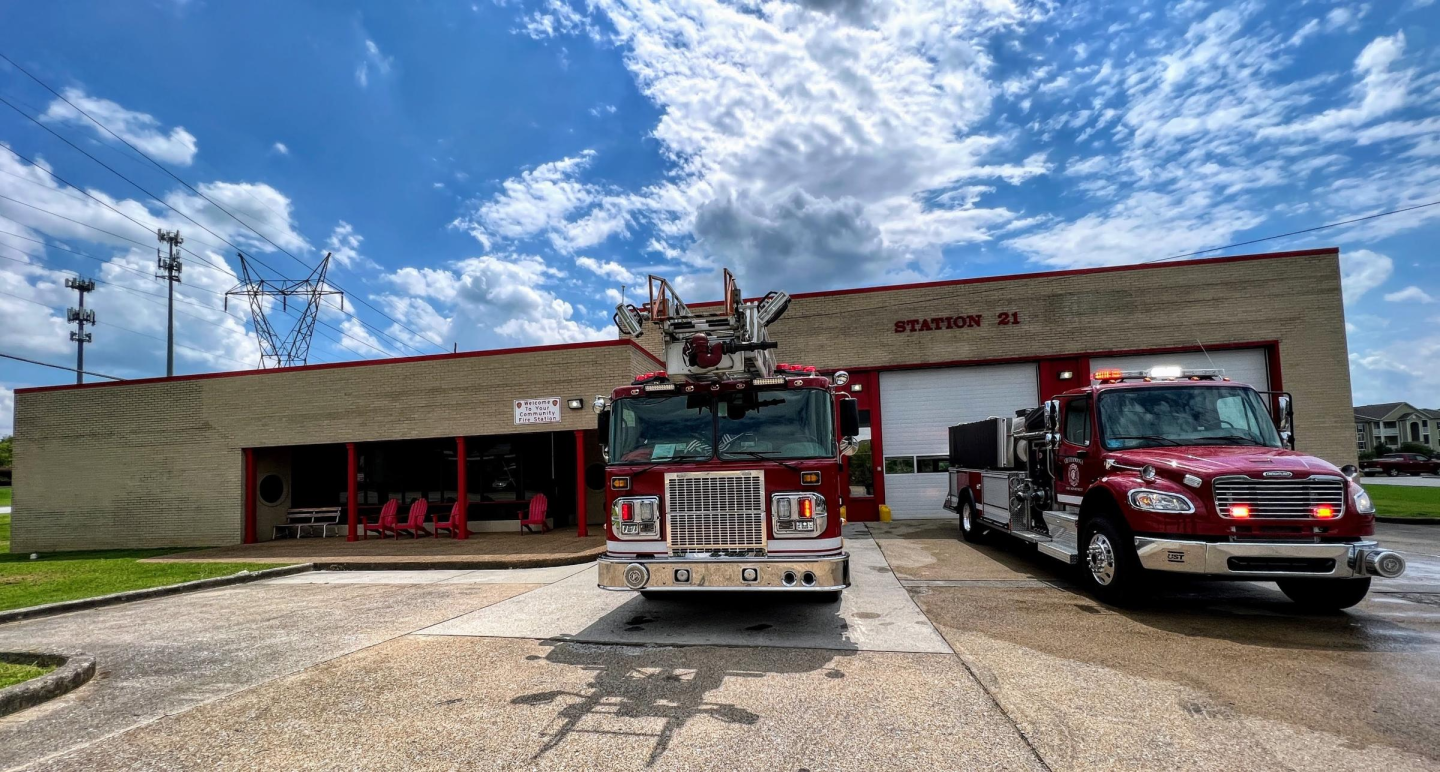 Two fire trucks parked in front of a building at fire station 21.