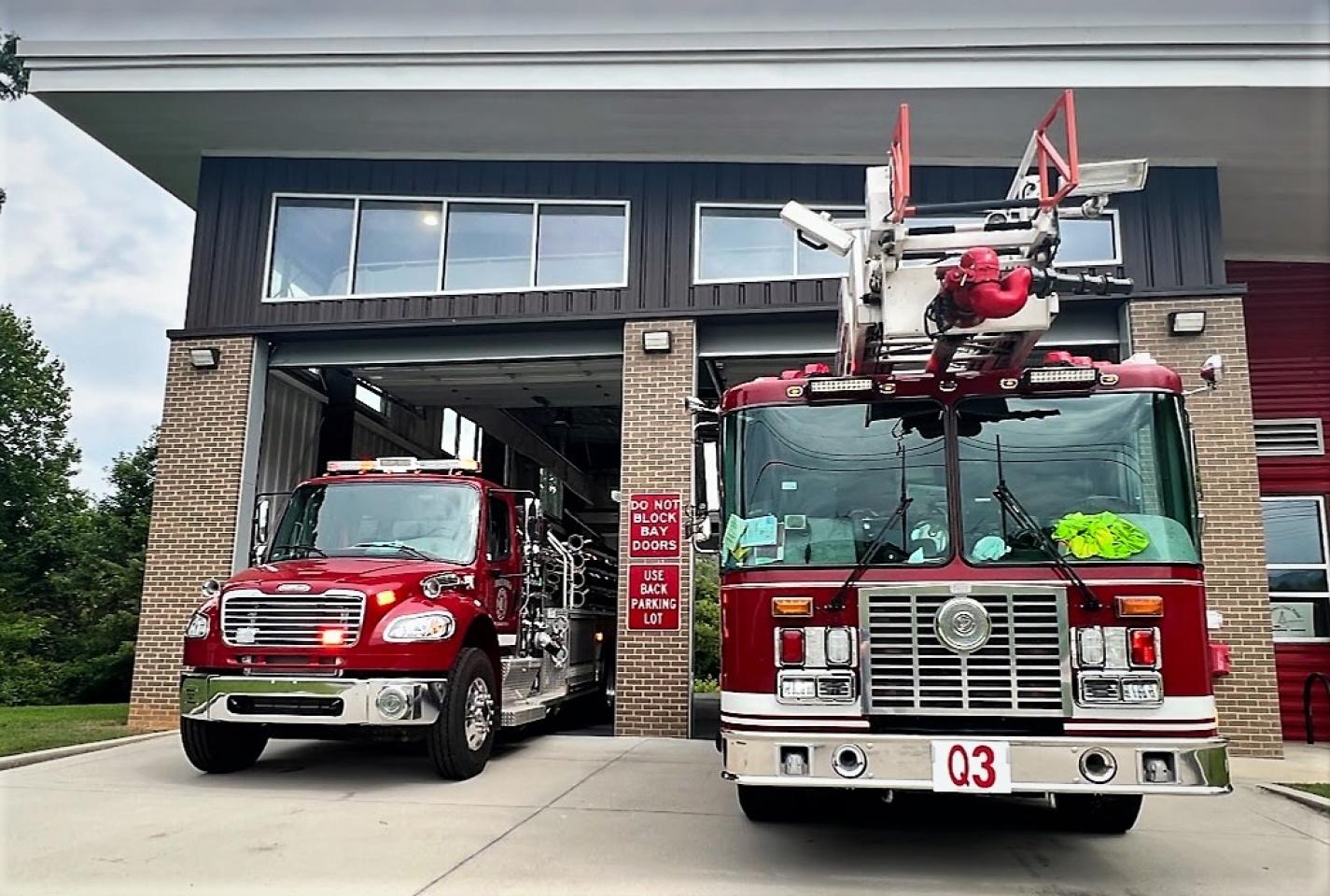  Two fire trucks parked in front of a building at fire station 3.