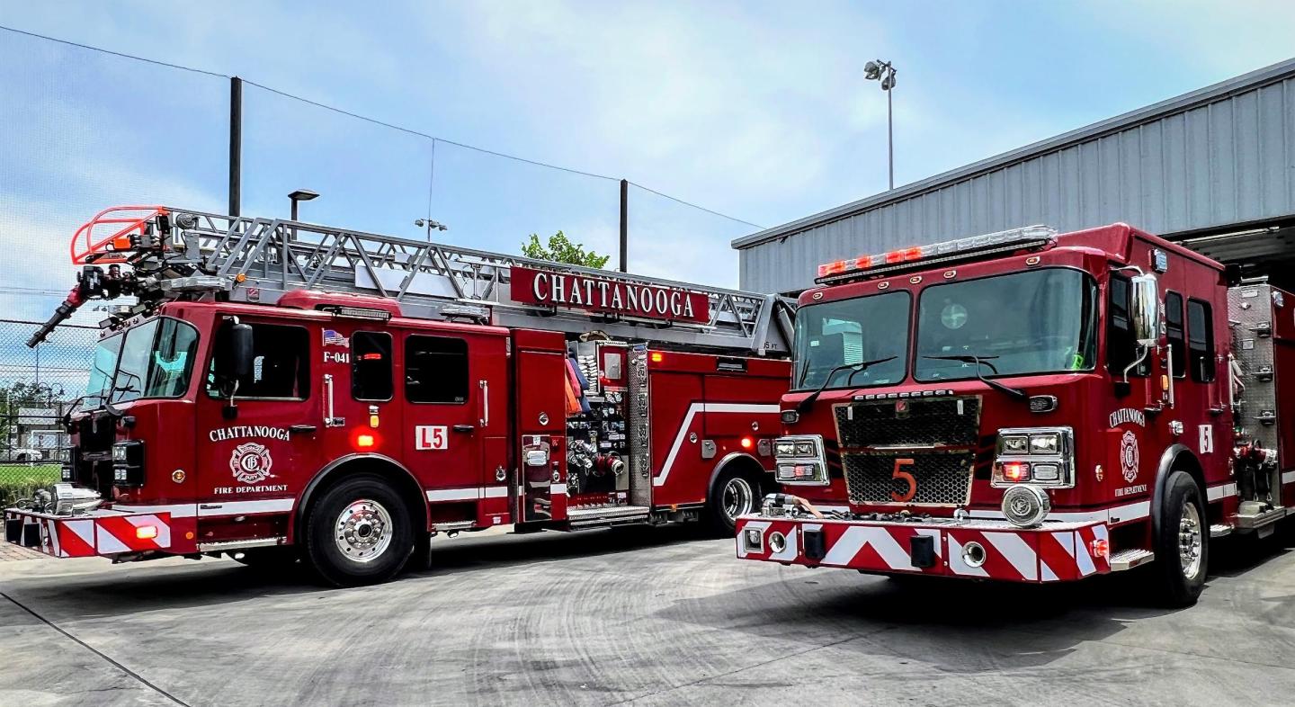 Dos camiones de bomberos rojos estacionados frente a un edificio en la estación de bomberos 5.