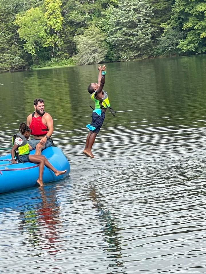 Niño saltando al lago