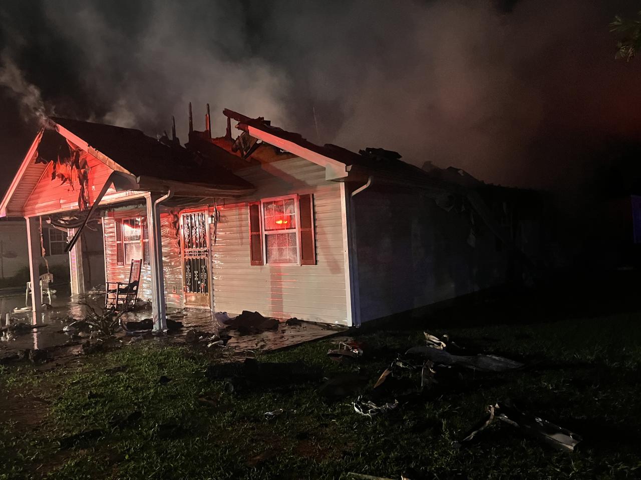 House with black charred roof and smoke coming out the top