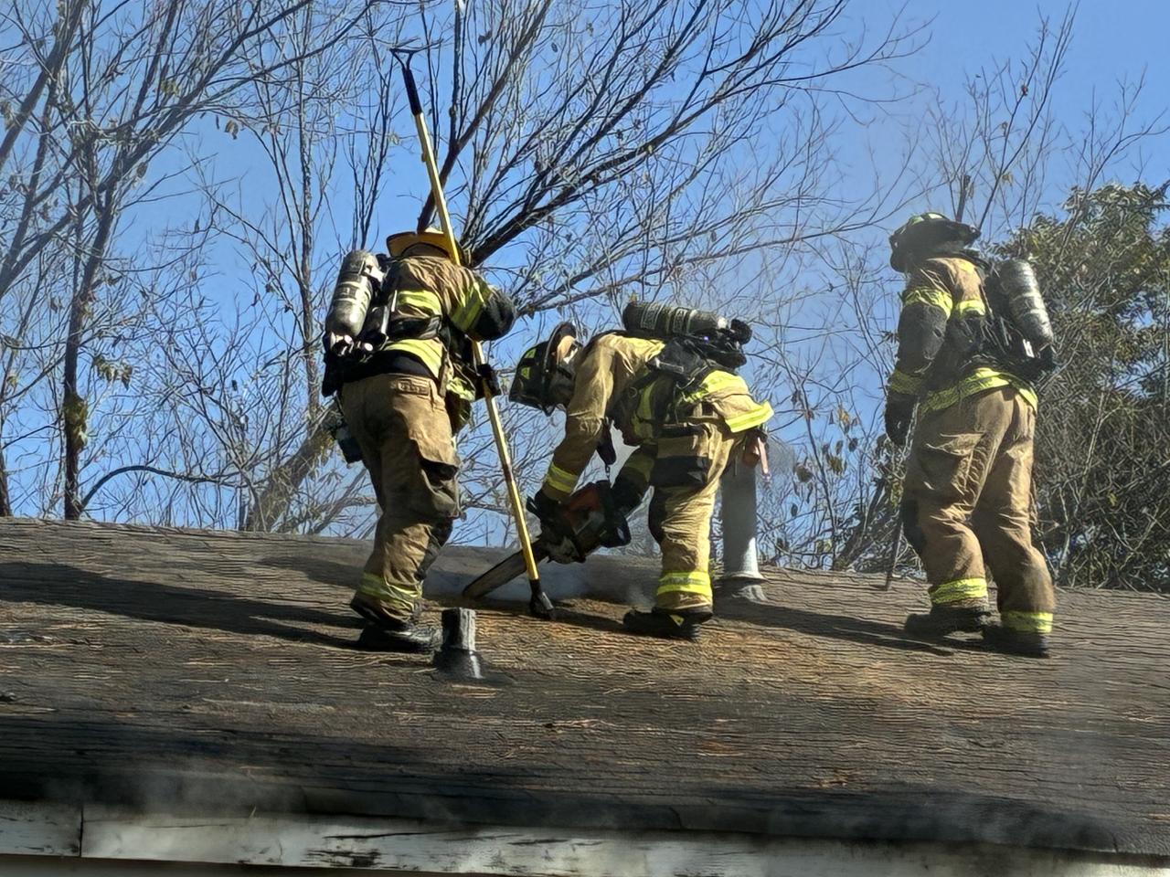 Bomberos en el techo de la casa