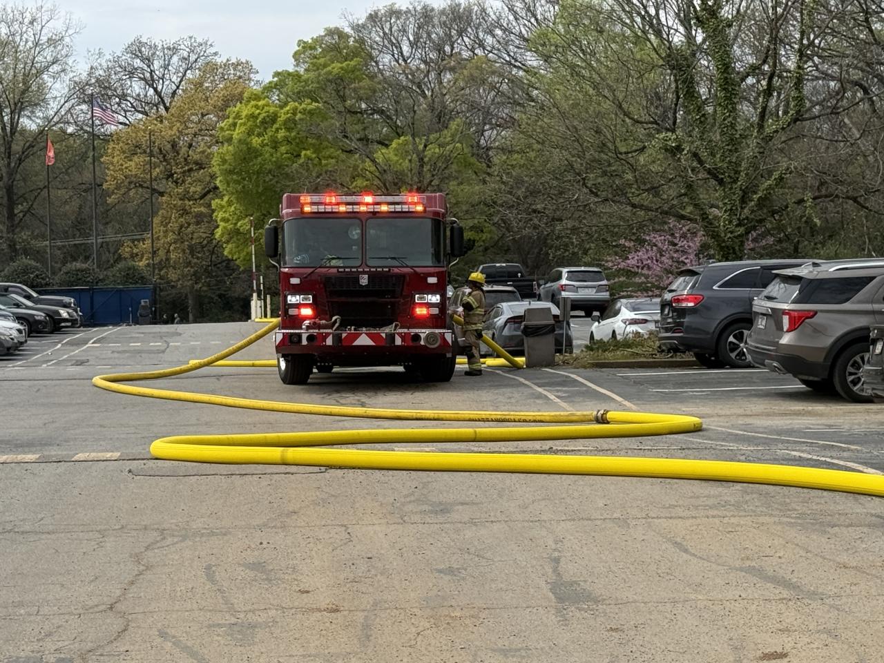 Firetruck in parking lot with yellow hose coming off