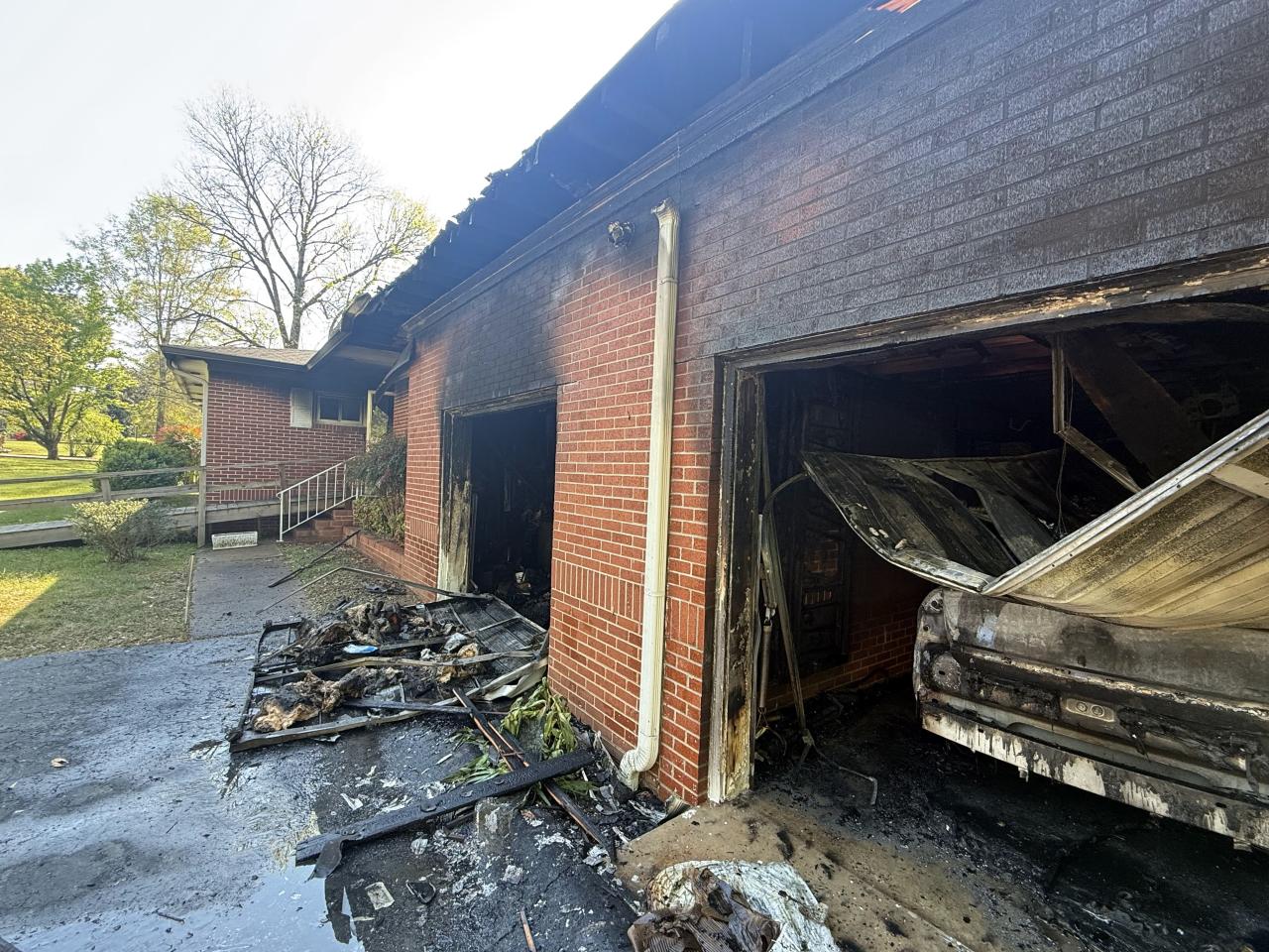 Burned house with burned car in the garage after fire was put out