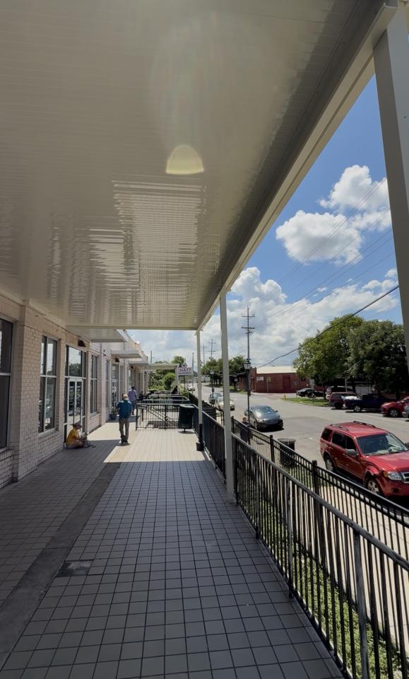 Side view of the awning with wall on the left and street on the right.