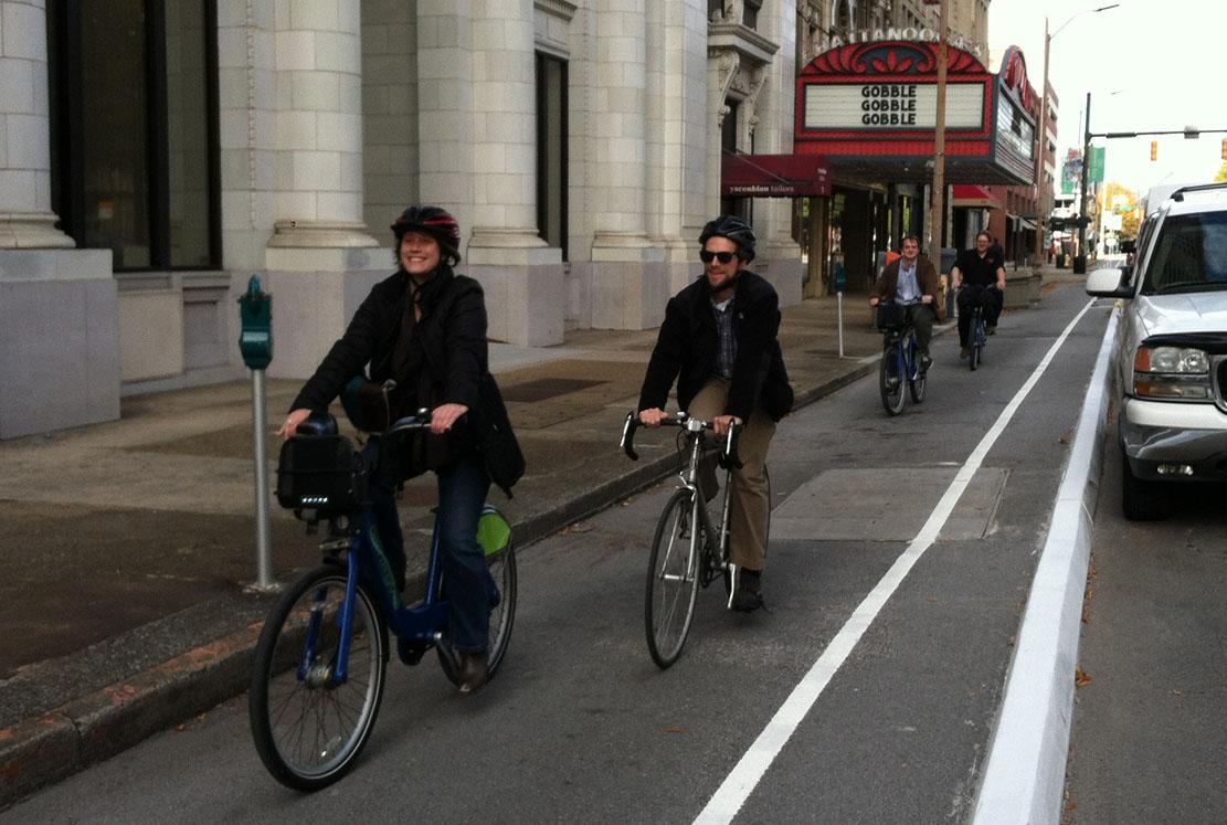 A diverse group of people riding bikes on a bike lane.