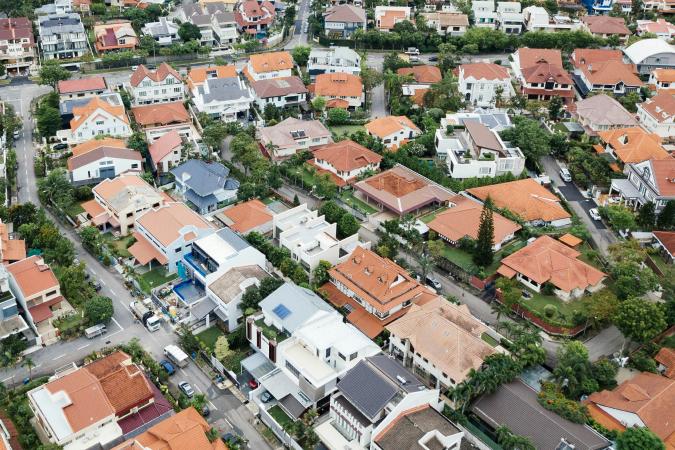 An aerial view of a residential neighborhood with various homes, representing the management and payment of garbage and recycling services.