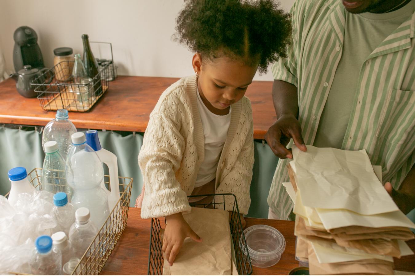 Child helping adult recycle in home