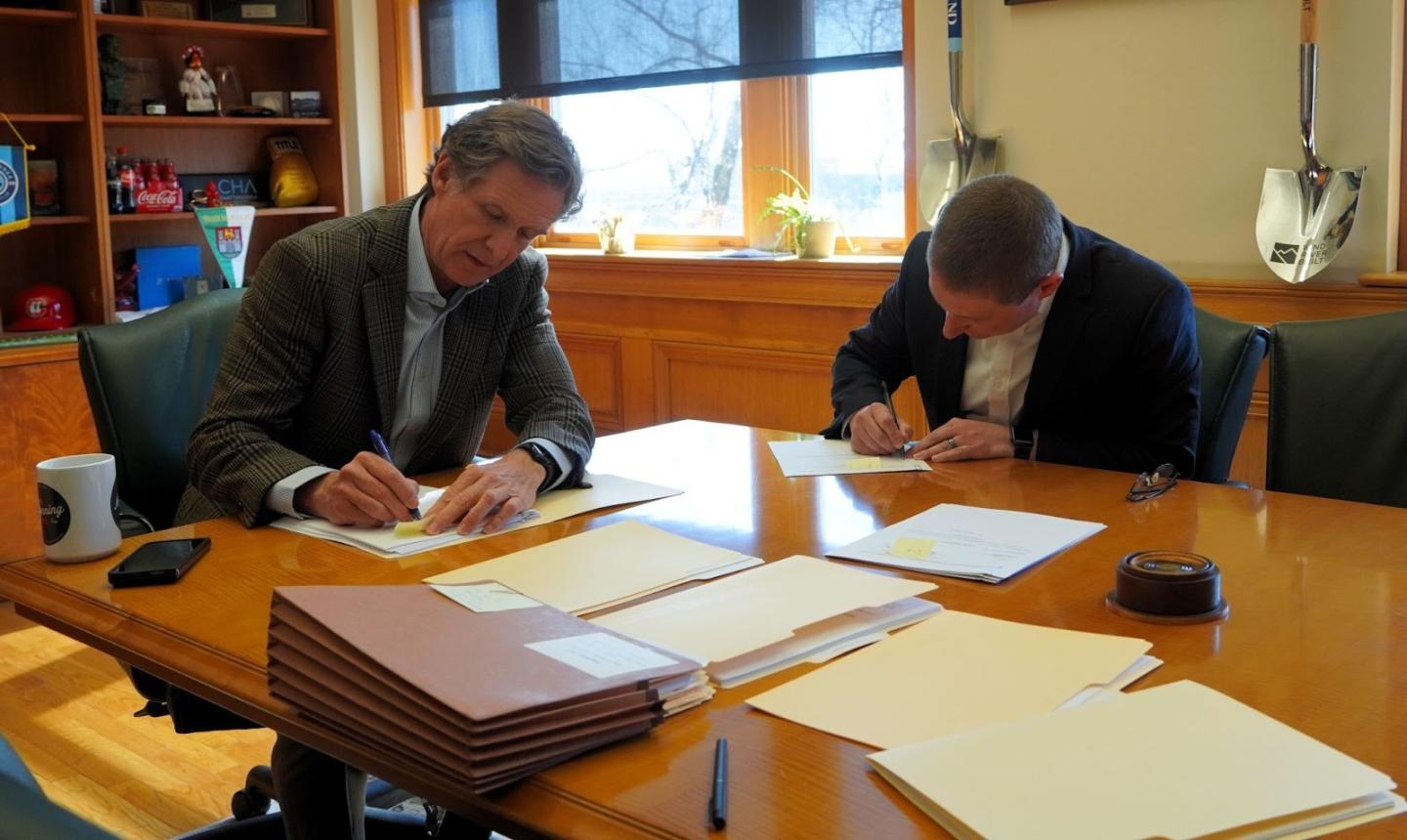Photo of Mayor Tim Kelly and Chief Financial Officer Weston Porter signing bond documents.