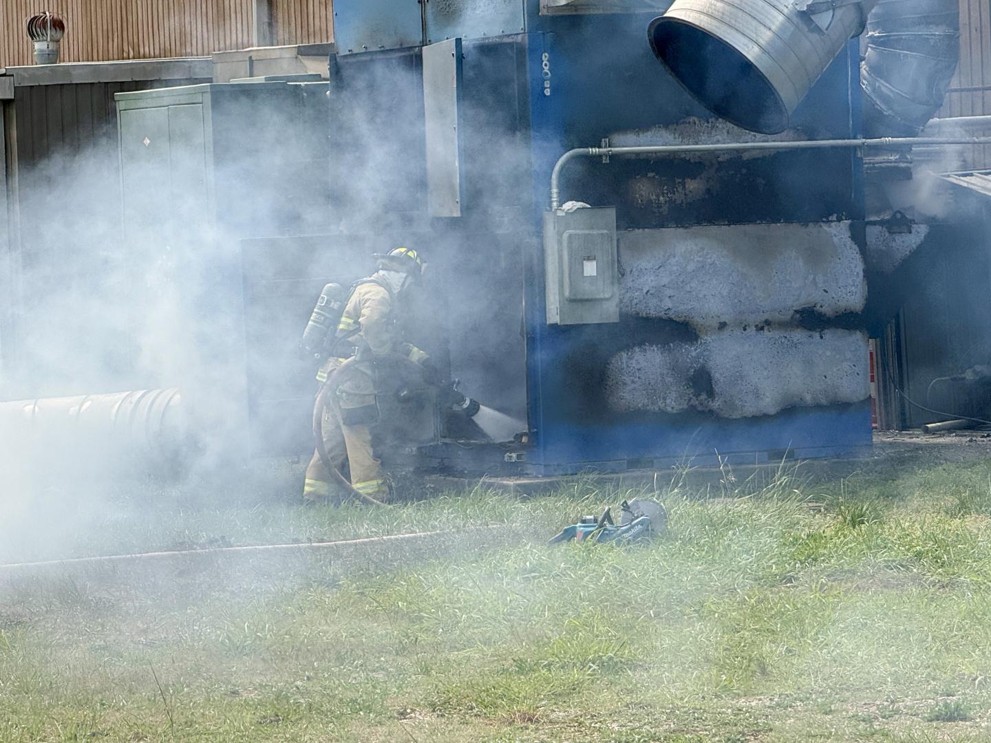 Fireman puts out fire in the back of factory