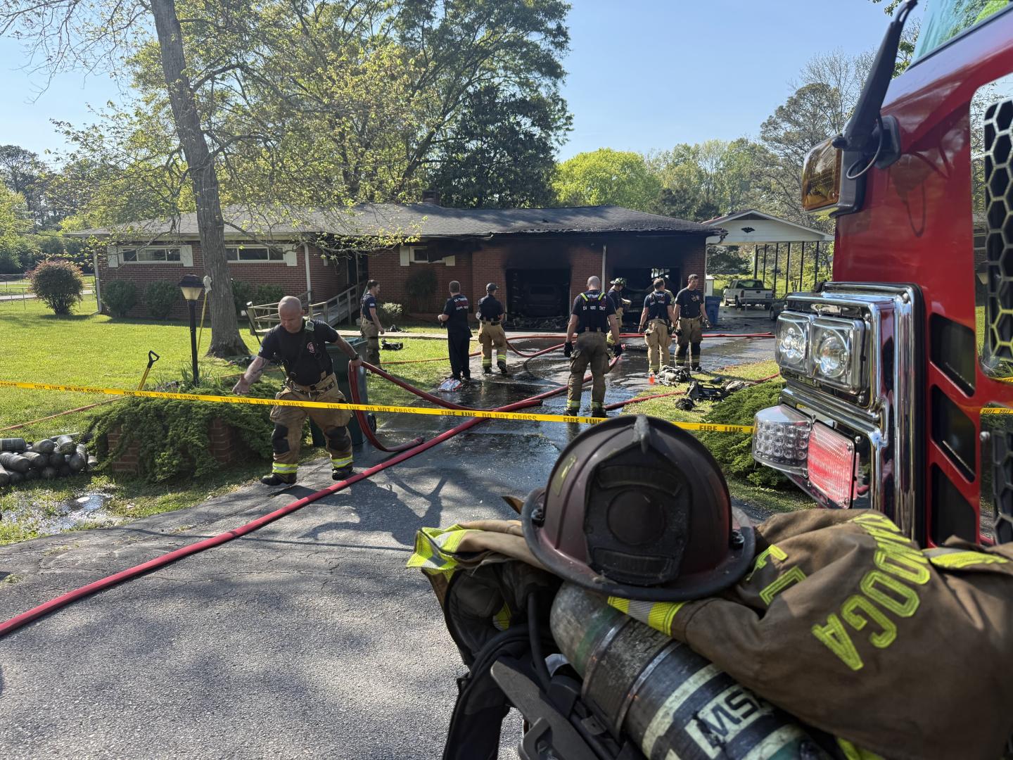 Firefighters standing outside of house where fire was put out.