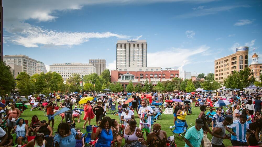 un gran grupo de personas reunidas en el césped en el centro de Chattanooga