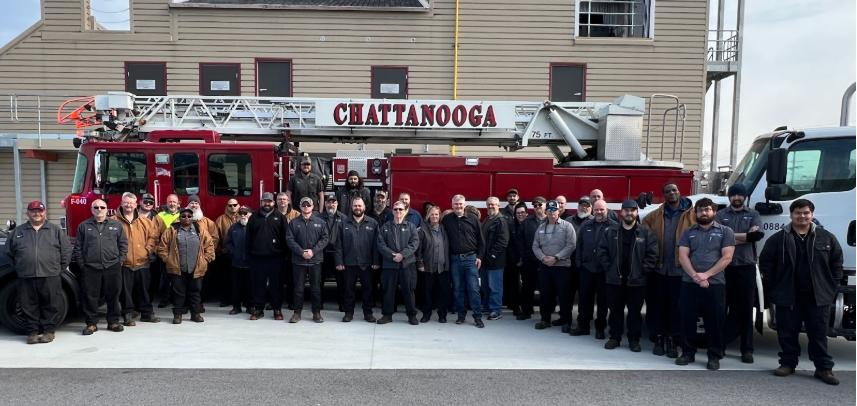 Firefighters standing in front of a fire truck.