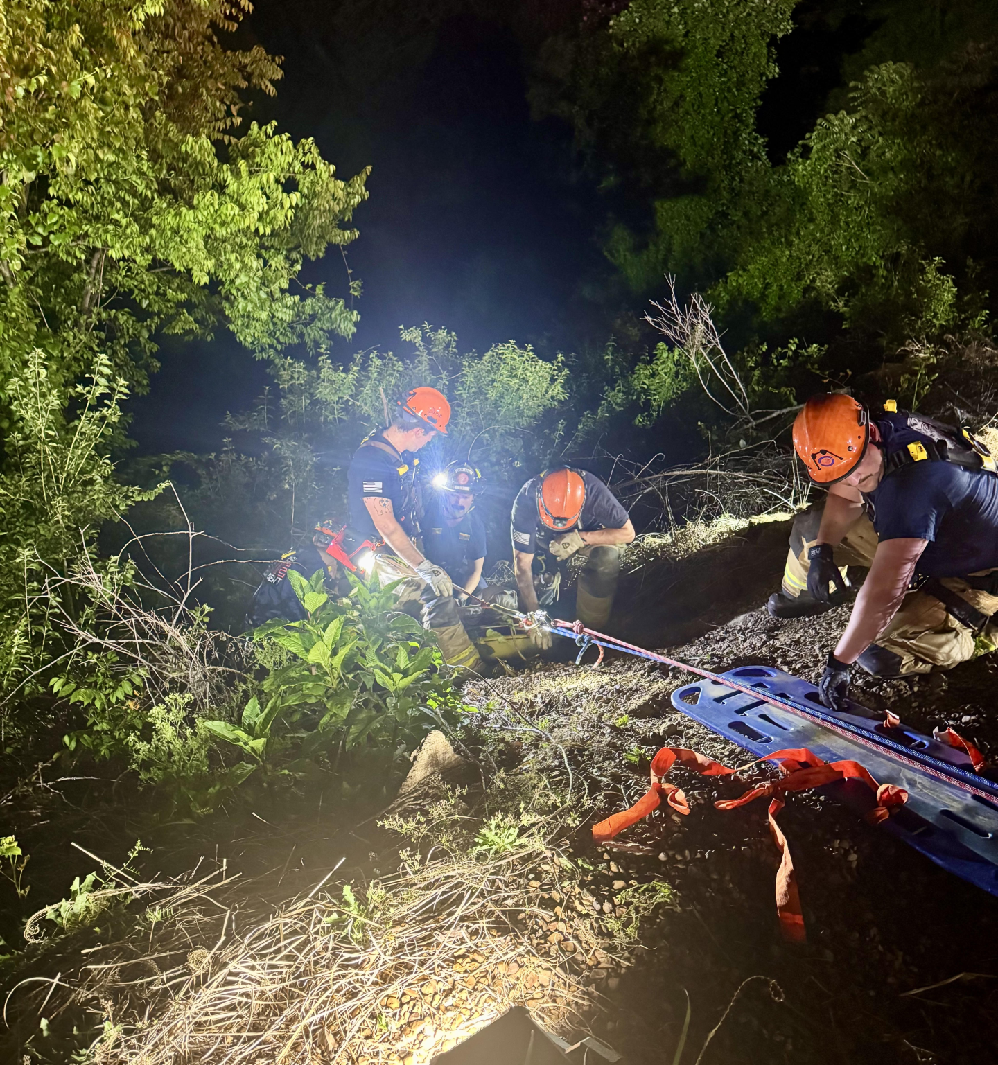 Firefighters using a rope to descend down a cliff