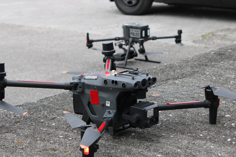 Dos drones negros sobre el pavimento.
