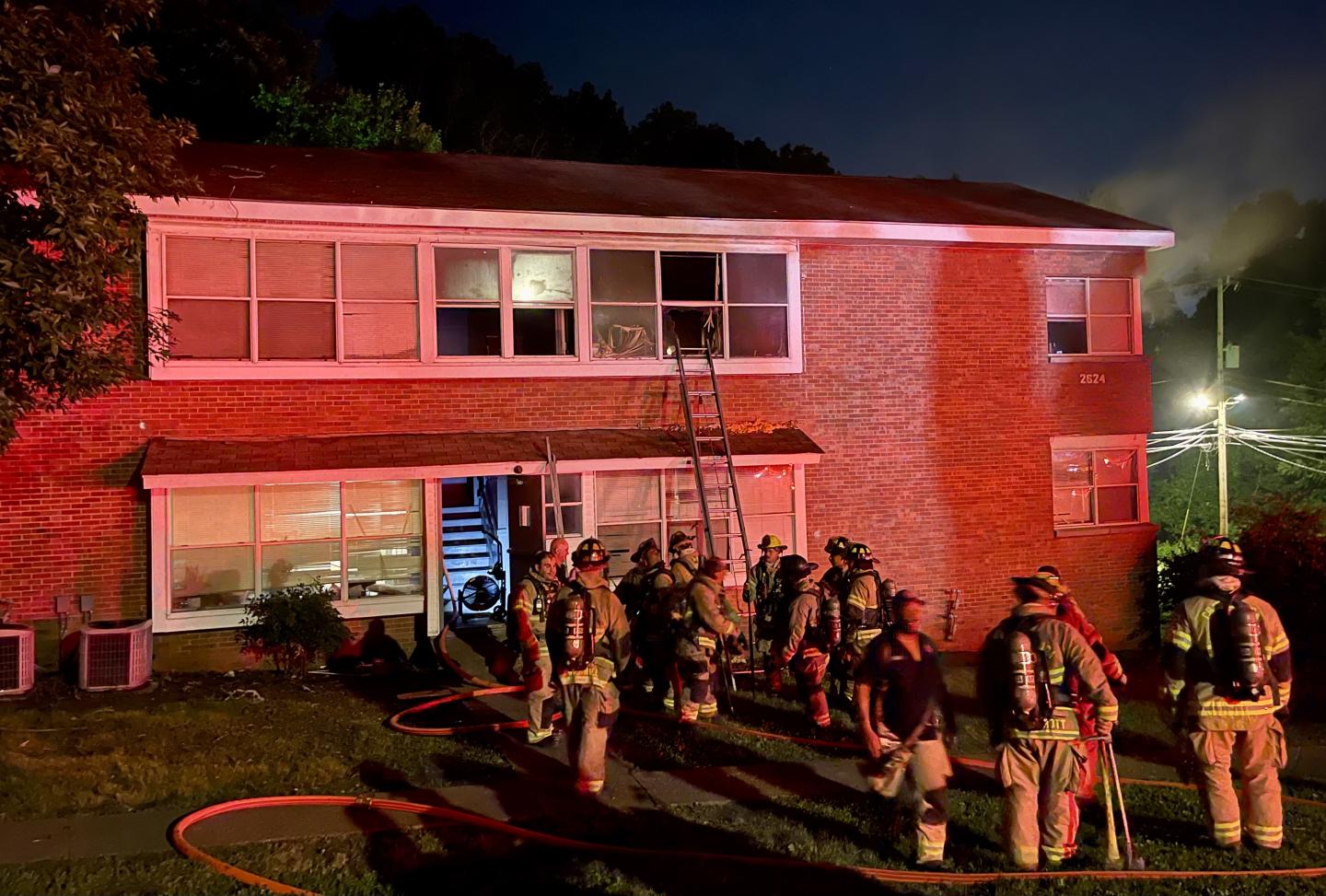 Firefighters standing outside apartment building